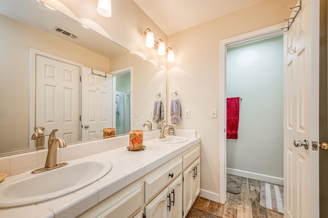1183 E Dinuba Ave, Fresno, CA 93725 - full bath featuring wood finished floors, double vanity, baseboards, and a shower