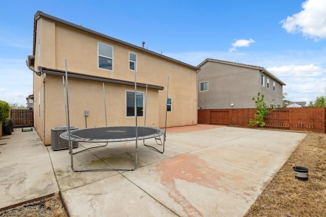 2830 Leanna Ave, Fresno, CA 93737 - back of house featuring a patio, a fenced backyard, stucco siding, a trampoline, and central AC unit