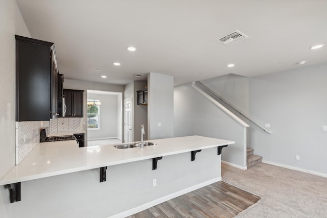 2830 Leanna Ave, Fresno, CA 93737 - kitchen featuring a sink, a peninsula, light countertops, recessed lighting, and a kitchen bar