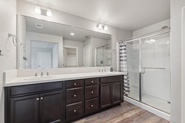 2830 Leanna Ave, Fresno, CA 93737 - bathroom featuring a shower stall, wood finished floors, and double vanity