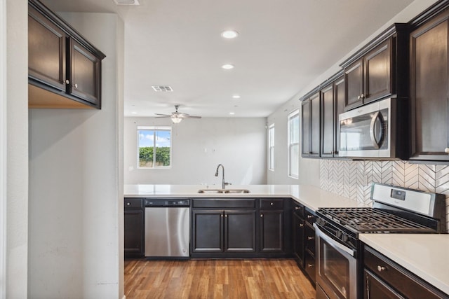 2830 Leanna Ave, Fresno, CA 93737 - kitchen with appliances with stainless steel finishes, a sink, a ceiling fan, tasteful backsplash, and light wood-style flooring