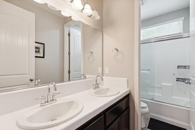 1697 Whiteash Ave, Clovis, CA 93619 - bathroom featuring toilet, double vanity, and bath / shower combo with glass door
