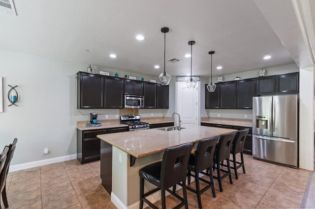 1697 Whiteash Ave, Clovis, CA 93619 - kitchen featuring stainless steel appliances, a sink, light stone counters, recessed lighting, and a breakfast bar area