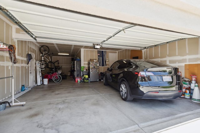 1697 Whiteash Ave, Clovis, CA 93619 - garage featuring a garage door opener and freestanding refrigerator