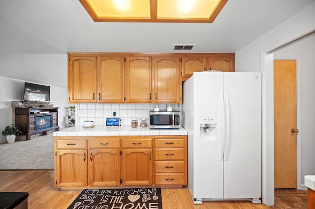 18118 Rd 26, Madera, CA 93638 - kitchen with white refrigerator with ice dispenser, stainless steel microwave, tasteful backsplash, and light wood finished floors