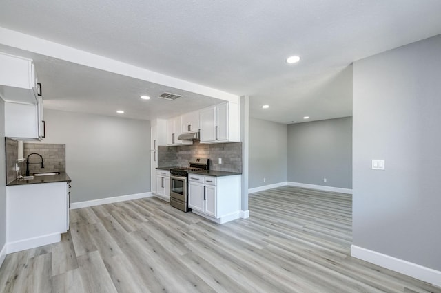 153 Birch, Fresno, CA 93650 - kitchen with stainless steel gas stove, dark countertops, a sink, decorative backsplash, and recessed lighting