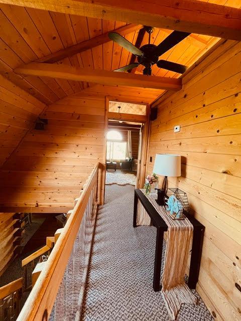 30670 Sentinel Dr, Coarsegold, CA 93614 - hallway featuring wood ceiling, wood walls, and carpet