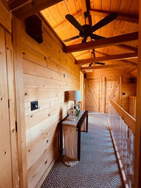 30670 Sentinel Dr, Coarsegold, CA 93614 - hallway with wooden walls, carpet flooring, and wooden ceiling
