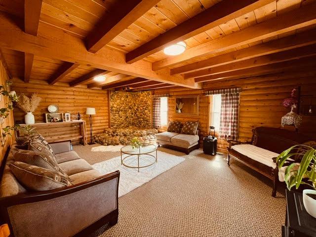 30670 Sentinel Dr, Coarsegold, CA 93614 - living area featuring rustic walls, wooden ceiling with exposed beams, and carpet floors