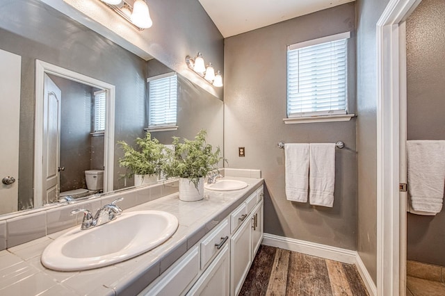 2631 Wrenwood Ave, Clovis, CA 93611 - full bathroom featuring double vanity, toilet, wood finished floors, and baseboards