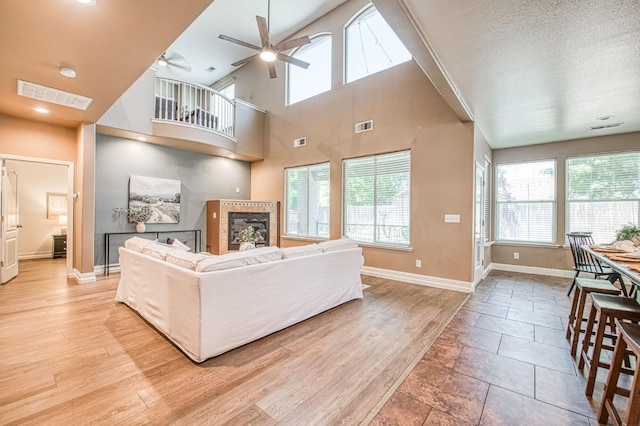 2631 Wrenwood Ave, Clovis, CA 93611 - living area featuring ceiling fan, baseboards, a fireplace, and a high ceiling