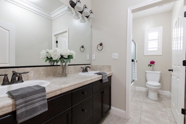 2138 El Paso Ave, Clovis, CA 93611 - bathroom with double vanity, toilet, crown molding, and bath / shower combo with glass door
