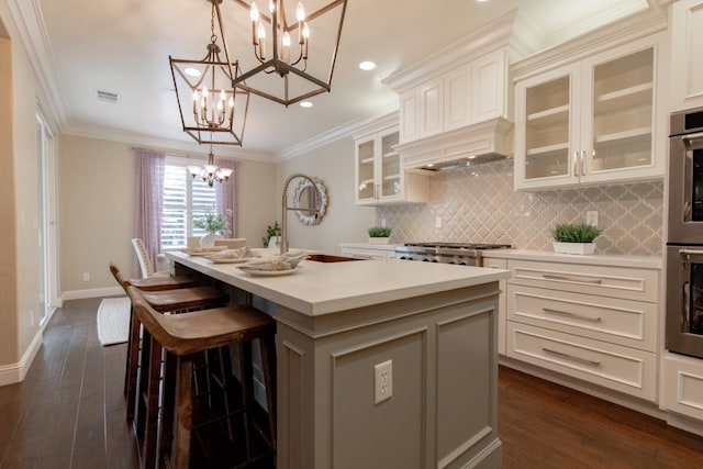 2138 El Paso Ave, Clovis, CA 93611 - kitchen featuring a chandelier, light countertops, tasteful backsplash, an island with sink, and dark wood-type flooring