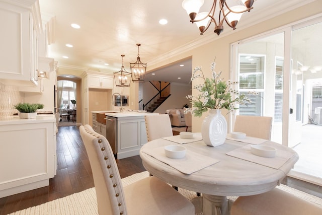 2138 El Paso Ave, Clovis, CA 93611 - dining space featuring a chandelier, stairway, crown molding, arched walkways, and dark wood-style floors