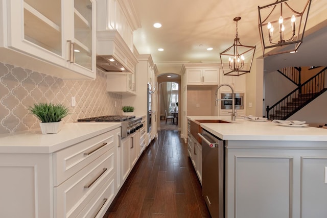 2138 El Paso Ave, Clovis, CA 93611 - kitchen featuring appliances with stainless steel finishes, arched walkways, a sink, glass insert cabinets, and a chandelier
