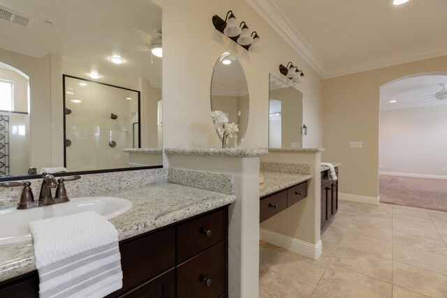 2138 El Paso Ave, Clovis, CA 93611 - bathroom featuring ceiling fan, crown molding, two vanities, tiled shower, and tile patterned floors