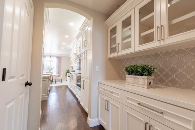 2138 El Paso Ave, Clovis, CA 93611 - bar area featuring arched walkways, dark wood-style floors, recessed lighting, backsplash, and baseboards