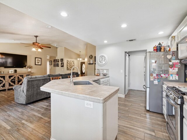 279 Lily Ave, Sanger, CA 93657 - kitchen featuring a sink, a peninsula, stainless steel appliances, ceiling fan, and light wood finished floors