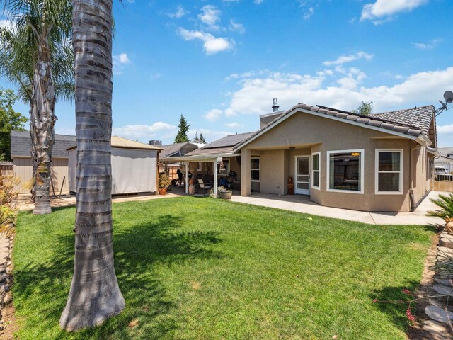 279 Lily Ave, Sanger, CA 93657 - back of house with solar panels, stucco siding, a patio, and a tiled roof