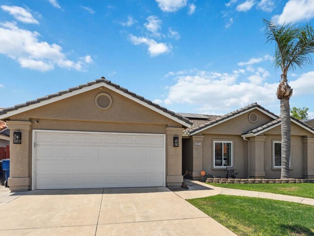 279 Lily Ave, Sanger, CA 93657 - view of front of property with driveway, a tiled roof, stucco siding, solar panels, and a garage