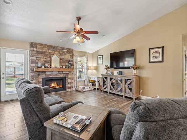 279 Lily Ave, Sanger, CA 93657 - living area featuring lofted ceiling, healthy amount of natural light, ceiling fan, wood finished floors, and a stone fireplace