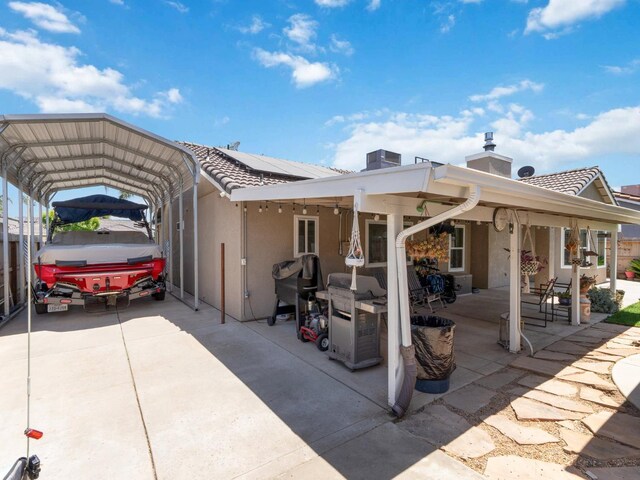 279 Lily Ave, Sanger, CA 93657 - back of property featuring stucco siding, roof mounted solar panels, a detached carport, and a tile roof