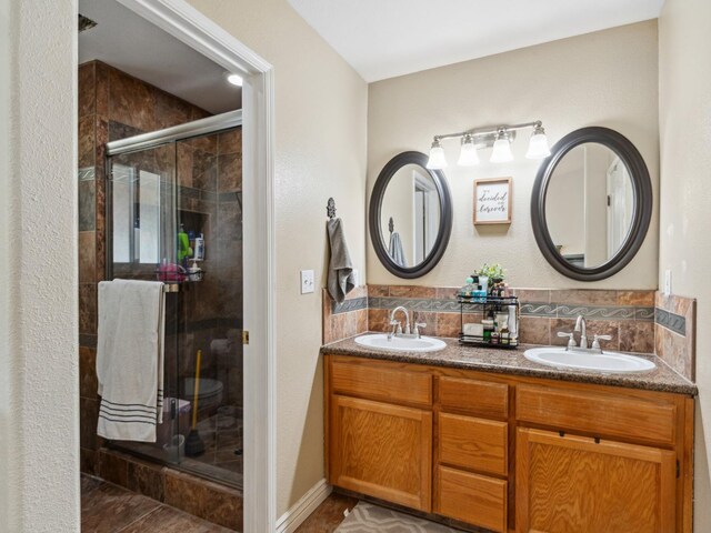 279 Lily Ave, Sanger, CA 93657 - bathroom featuring a stall shower, double vanity, backsplash, and tile patterned floors