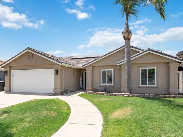 279 Lily Ave, Sanger, CA 93657 - ranch-style house featuring a garage, stucco siding, driveway, roof mounted solar panels, and a front yard