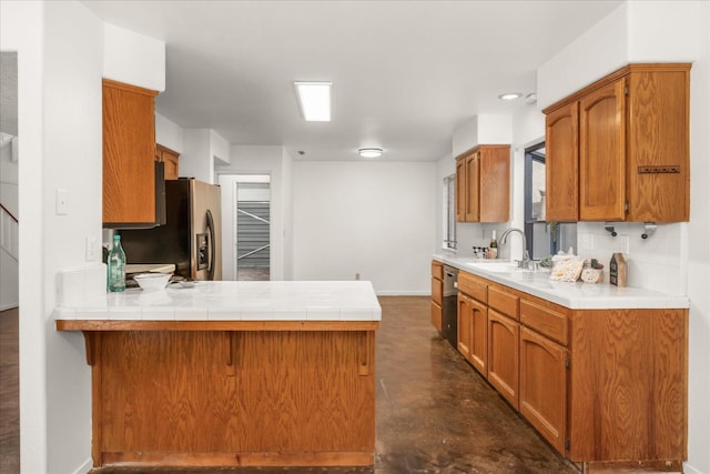473 E Alluvial Ave Unit 107, Fresno, CA 93720 - kitchen featuring a sink, a peninsula, finished concrete flooring, dishwashing machine, and brown cabinets