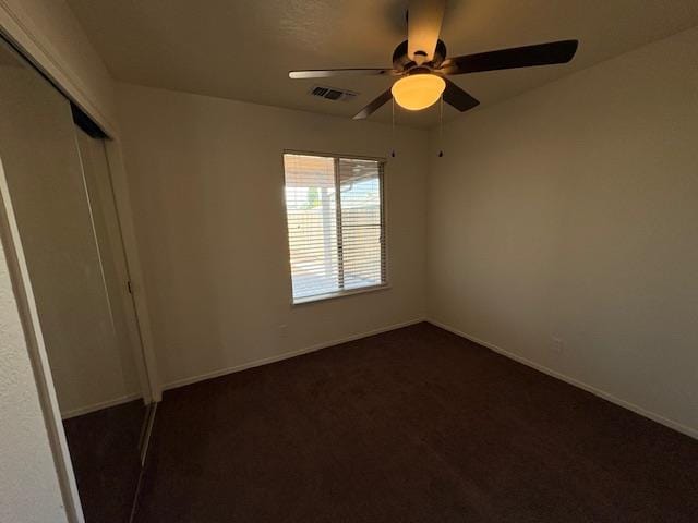 2407 W Carmen Ave, Fresno, CA 93728 - unfurnished bedroom featuring a closet, baseboards, a ceiling fan, and dark carpet