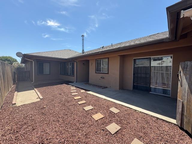 2407 W Carmen Ave, Fresno, CA 93728 - rear view of property featuring stucco siding and a patio area