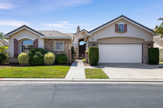 5125 N Via Amore, Fresno, CA 93711 - view of front of house with stucco siding, stone siding, driveway, and a garage