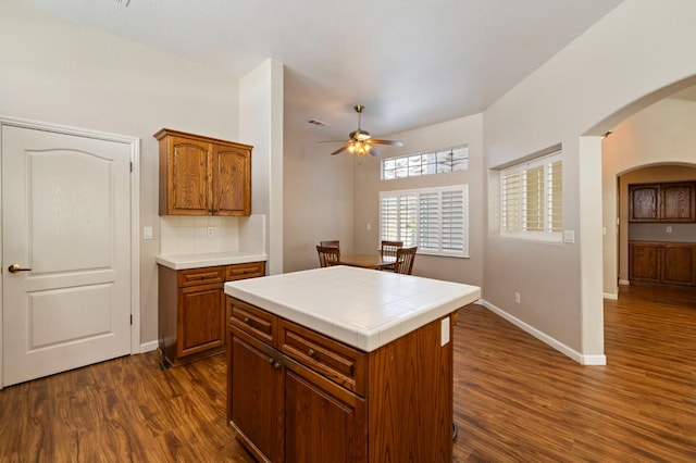 5125 N Via Amore, Fresno, CA 93711 - kitchen featuring ceiling fan, arched walkways, dark wood-type flooring, and tile countertops