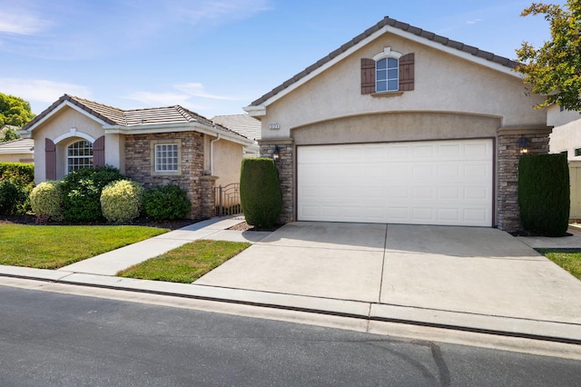 5125 N Via Amore, Fresno, CA 93711 - view of front facade with stone siding, stucco siding, a tile roof, and an attached garage