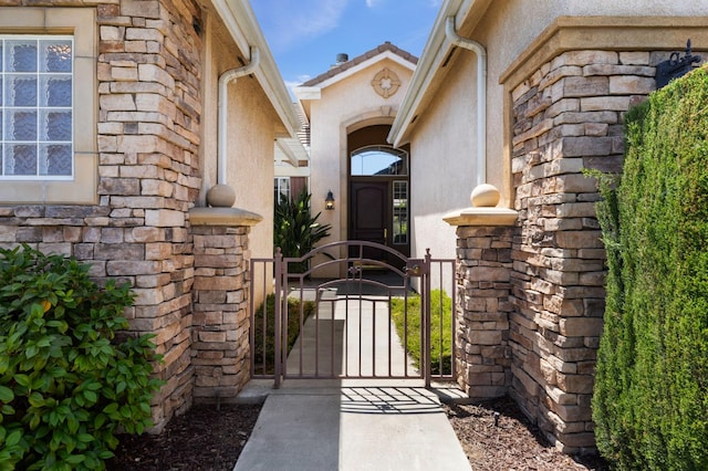 5125 N Via Amore, Fresno, CA 93711 - entrance to property with stucco siding, stone siding, and a gate