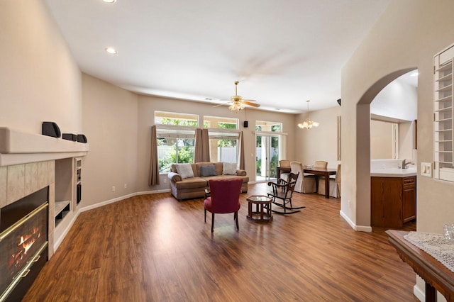 5125 N Via Amore, Fresno, CA 93711 - living area with a tiled fireplace, dark wood finished floors, a ceiling fan, arched walkways, and recessed lighting