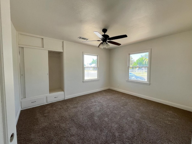 1305 E Fedora Ave, Fresno, CA 93704 - unfurnished bedroom with dark colored carpet, baseboards, a closet, a textured ceiling, and a ceiling fan