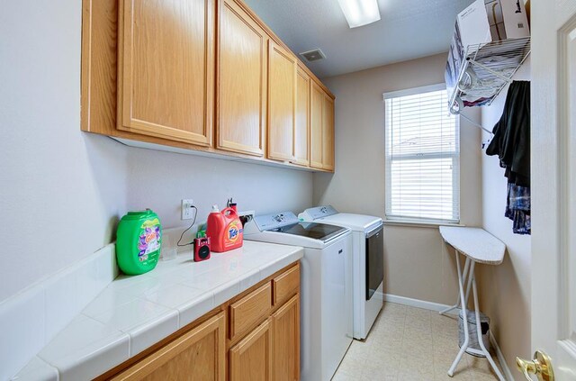 2701 Glade Ave, Madera, CA 93637 - laundry room with cabinet space, independent washer and dryer, light flooring, and baseboards