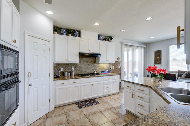 2701 Glade Ave, Madera, CA 93637 - kitchen with a sink, black appliances, decorative backsplash, light tile patterned flooring, and white cabinetry