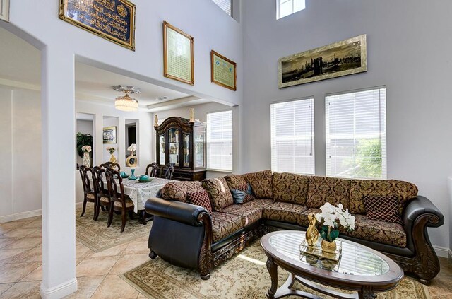 2701 Glade Ave, Madera, CA 93637 - living room with baseboards, light tile patterned flooring, and a towering ceiling