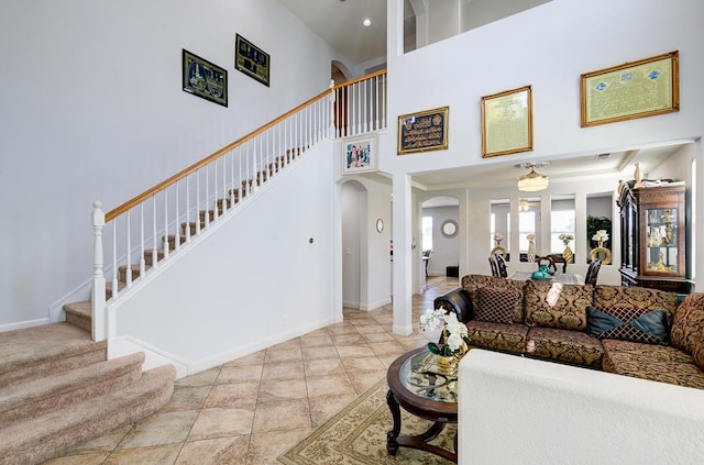 2701 Glade Ave, Madera, CA 93637 - living area with arched walkways, stairs, a towering ceiling, and baseboards