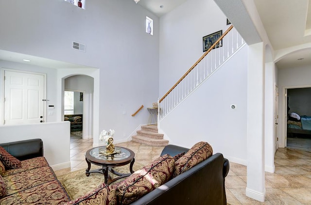 2701 Glade Ave, Madera, CA 93637 - living area with arched walkways, a towering ceiling, stairs, and plenty of natural light