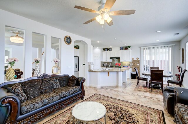 2701 Glade Ave, Madera, CA 93637 - living room with a ceiling fan, arched walkways, light tile patterned flooring, and recessed lighting