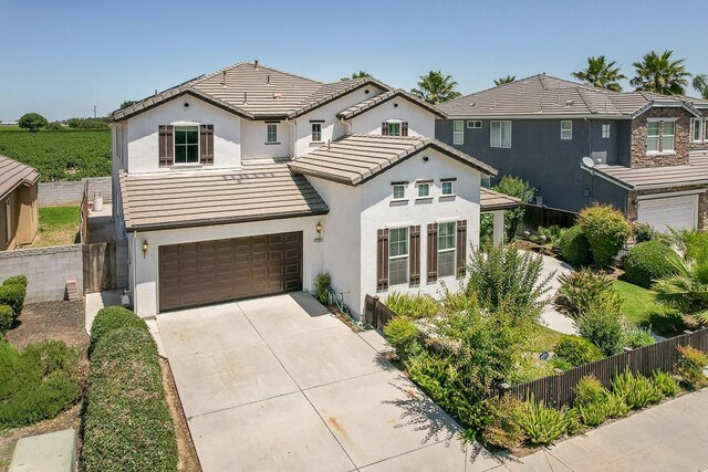 2701 Glade Ave, Madera, CA 93637 - view of front facade with an attached garage, a tiled roof, concrete driveway, and stucco siding
