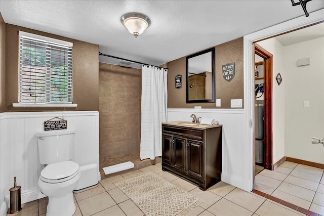 42939 Scenic Dr, Oakhurst, CA 93644 - full bathroom with a textured ceiling, toilet, a wainscoted wall, tiled shower, and vanity