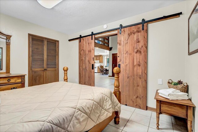 42939 Scenic Dr, Oakhurst, CA 93644 - bedroom featuring a barn door, tile patterned flooring, and a closet