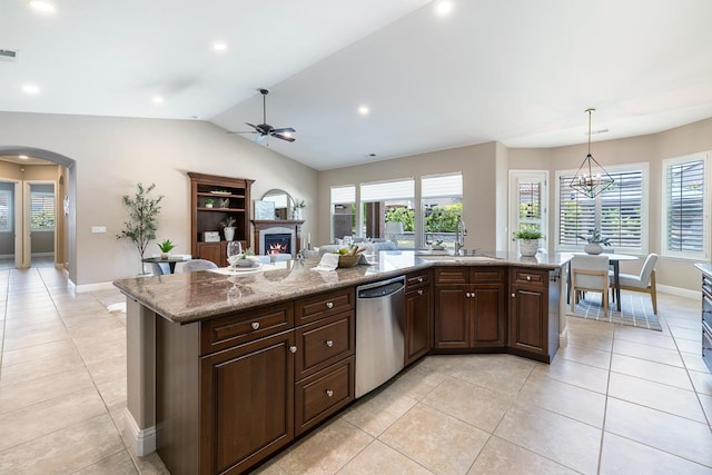 1977 N Dara Ave, Clovis, CA 93619 - kitchen featuring dishwasher, a sink, a warm lit fireplace, vaulted ceiling, and light tile patterned floors