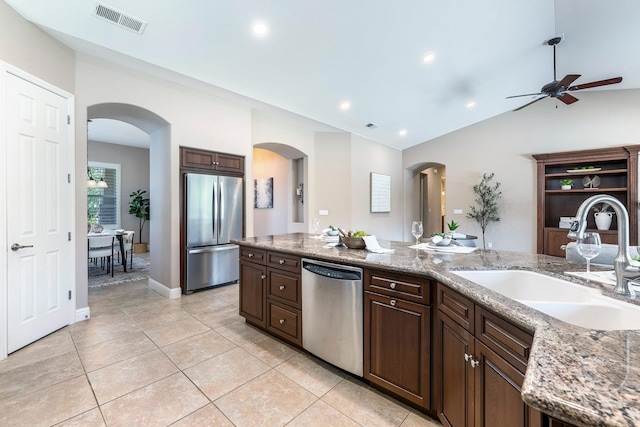 1977 N Dara Ave, Clovis, CA 93619 - kitchen with stainless steel appliances, a sink, a ceiling fan, arched walkways, and light tile patterned flooring
