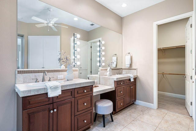 1977 N Dara Ave, Clovis, CA 93619 - bathroom with two vanities, a ceiling fan, tile patterned flooring, a walk in closet, and baseboards