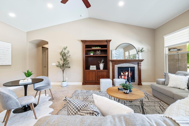 1977 N Dara Ave, Clovis, CA 93619 - living room featuring arched walkways, a ceiling fan, baseboards, a glass covered fireplace, and lofted ceiling
